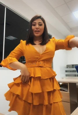 3. Hot Milagro Flores Shows Cleavage in Orange Dress