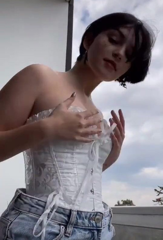 4. Sexy Angelique Shows Cleavage in White Corset on the Balcony