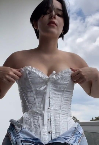 3. Desirable Angelique Shows Cleavage in White Corset on the Balcony